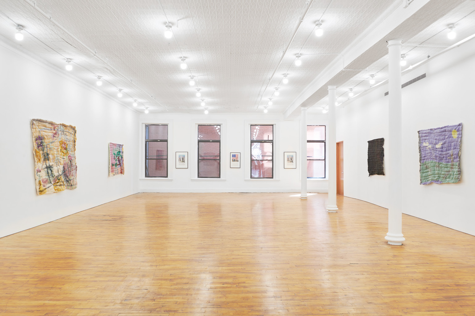 An installation view of the paintings in an exhibition.